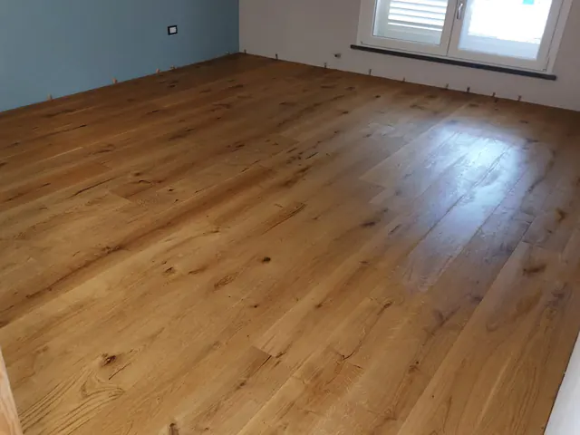 Camera con parete azzurra e parquet prefinito in rovere