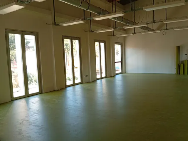 Grande sala con vetrate e pavimento in linoleum verde