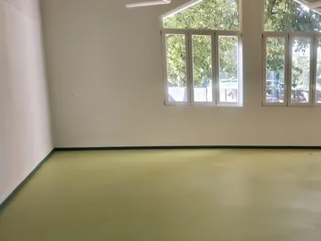 Salone con finestre a punta e pavimento in linoleum verde