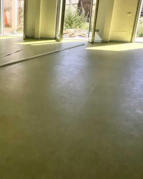 Salone con portefinestre e pavimento in linoleum verde