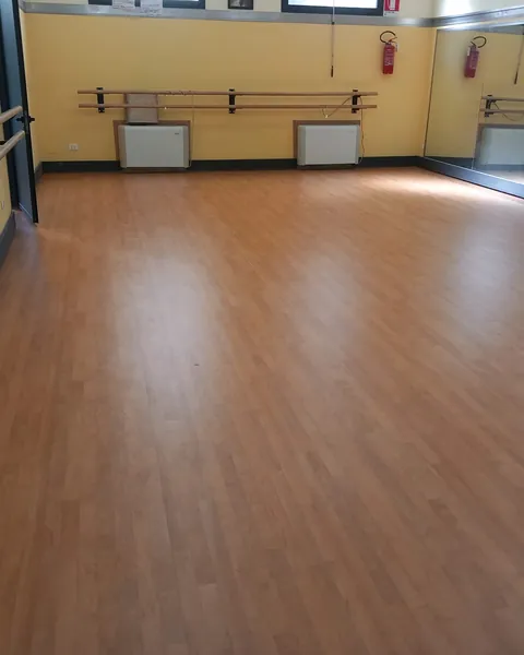 Sala danza con sbarre e pavimento sportivo effetto legno
