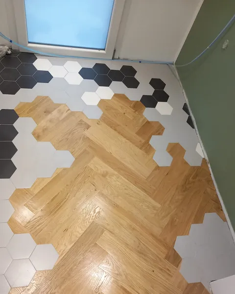 Stanza con parquet prefinito a spina di pesce tra esagonette