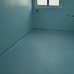 Stanza vuota con pavimento e pareti rivestite in PVC azzurro