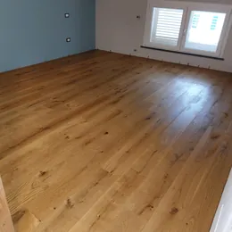 Camera con parete azzurra e parquet prefinito in rovere