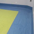 Locale con pavimento in linoleum giallo-verde e bordo blu