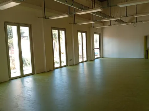 Grande sala con vetrate e pavimento in linoleum verde