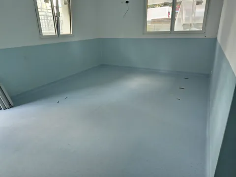 Stanza con pavimento in PVC azzurro e pareti rivestite a metà