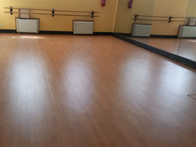 Sala danza con specchi e pavimento sportivo effetto legno