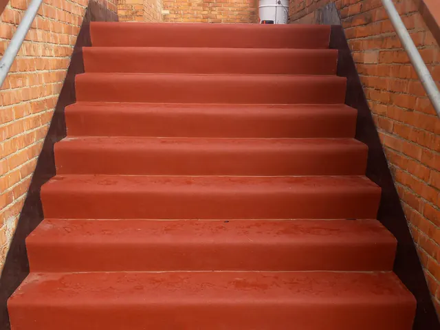 Scala esterna tra muri di mattoni, con gradini in gomma rossa