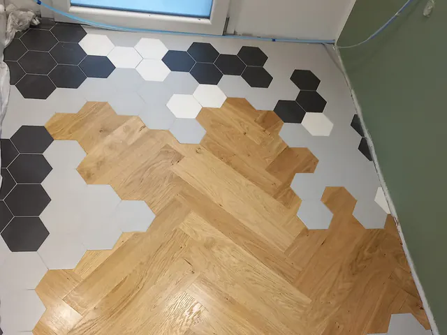 Stanza con parquet prefinito a spina di pesce tra esagonette